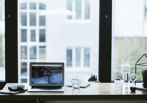 Modern clean desk with laptop and neon light decorations